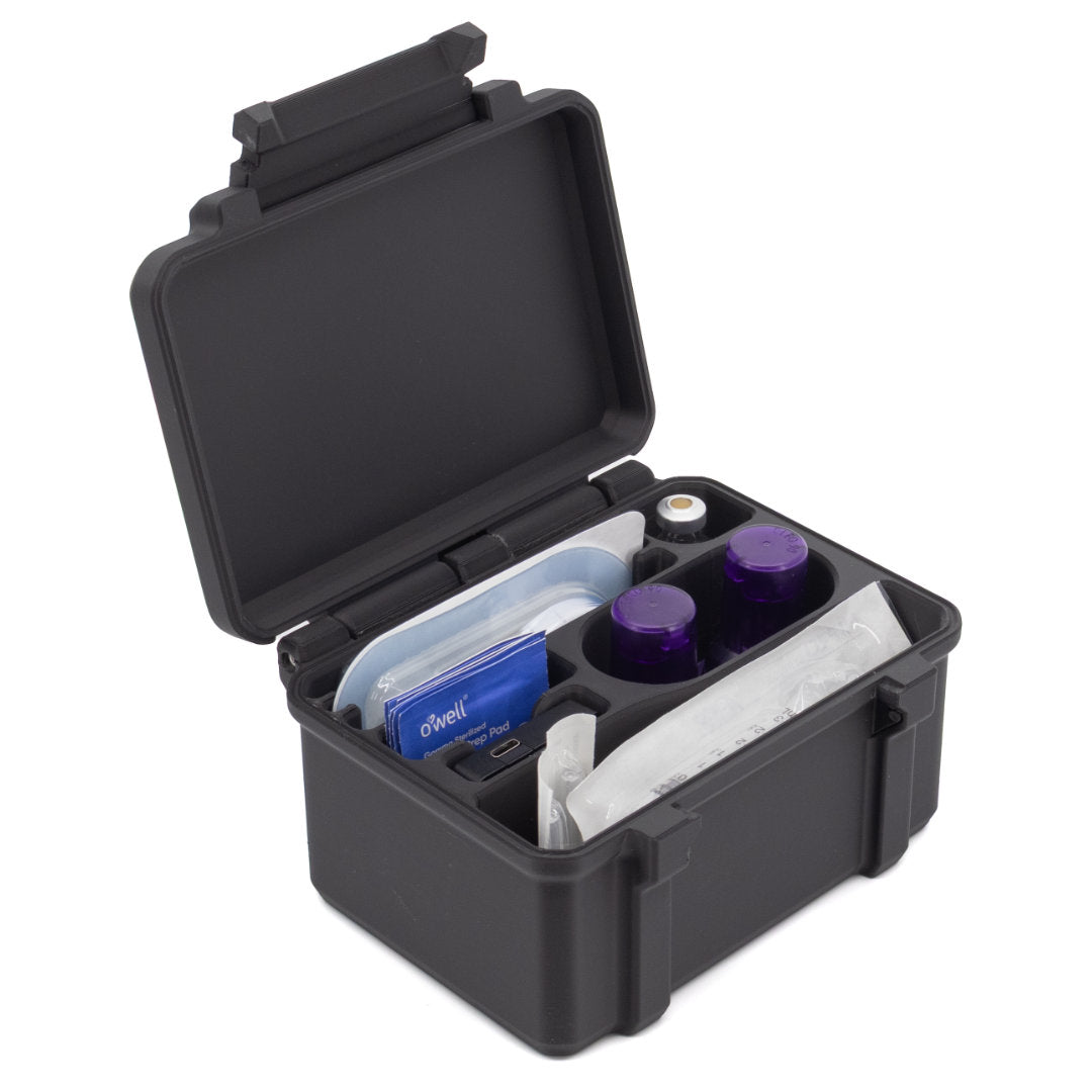 A black plastic medical storage case shown open on a white background, containing small bottles, a blue packet, and gauze or pads in molded compartments.